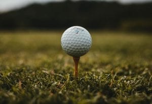 a golf ball on a tee with its 336 different dimples