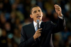 Barack Obama talking to the crowd with a microphone 