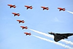 Red Arrows flying in formation with a Vulcan Bomber