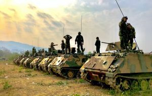 soldiers standing on their tanks