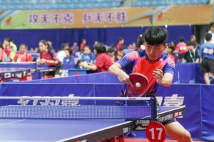 A large hall full of people playing table tennis