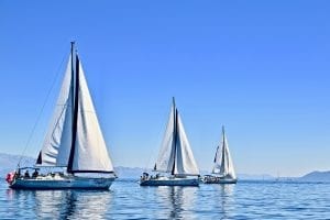 three yachts sailing on calm waters