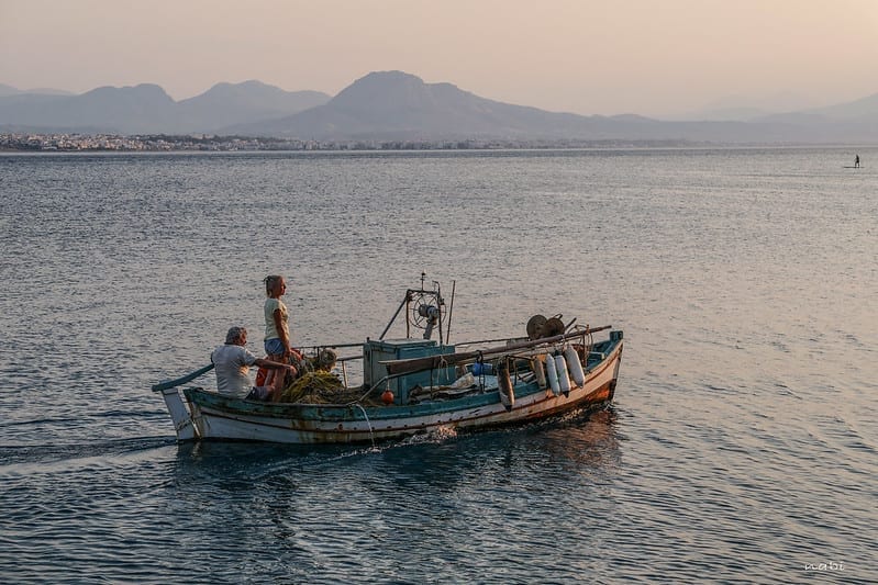 a small fishing boat, heading out on a calm morning