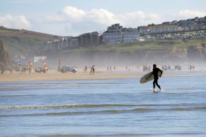 Man walking out of the sea with a surfboard