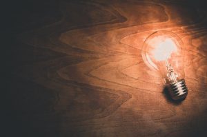 a light bulb shining against a backdrop of wood