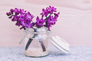 a flower jar with purple flowers 